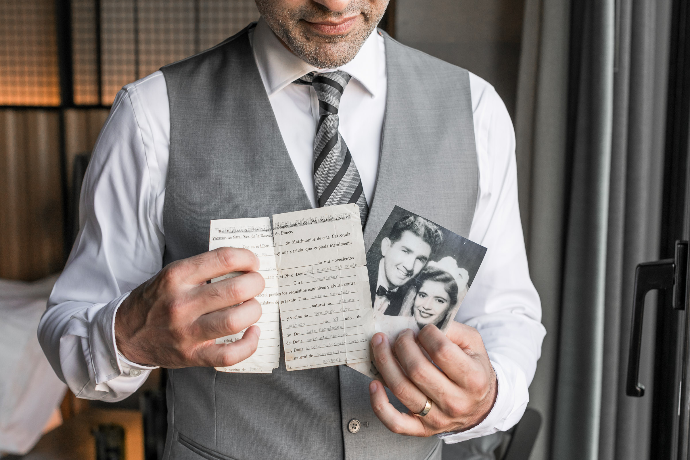 groom at 1 hotel brooklyn bridge holding parents wedding photo by destination wedding photographer Julie Ferneau