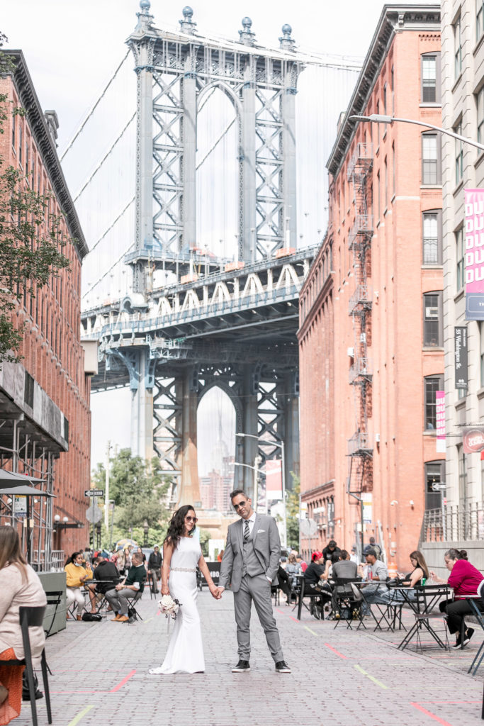 Manhattan Bridge behind wedding couple by destination wedding photographer Julie Ferneau